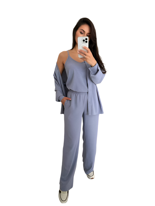 Woman taking a selfie wearing a light blue outfit on a white background