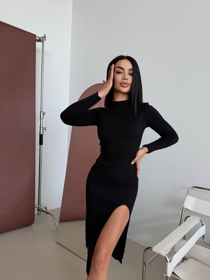 Woman in a black dress posing in a photo studio setting.
