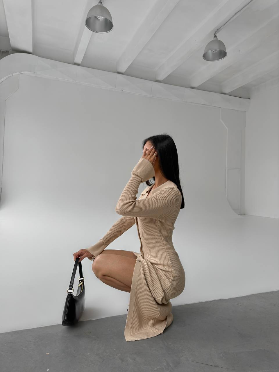 Woman in a beige dress posing in a studio setting