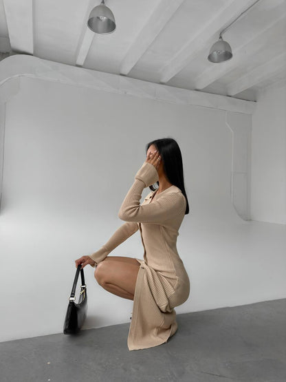 Woman in a beige dress posing in a studio setting