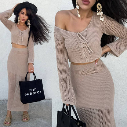 Woman wearing a beige knit outfit with a black tote bag against a white background