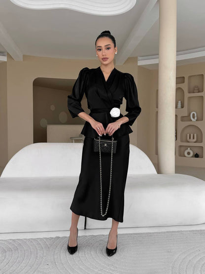 Woman in a black outfit standing in a modern interior setting