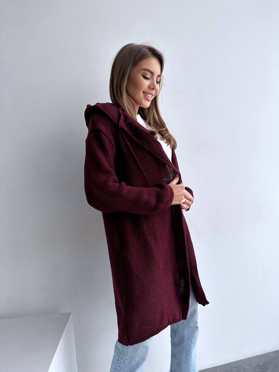 Woman wearing a burgundy coat against a white background