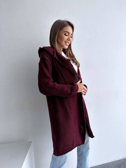 Woman wearing a burgundy coat against a white background