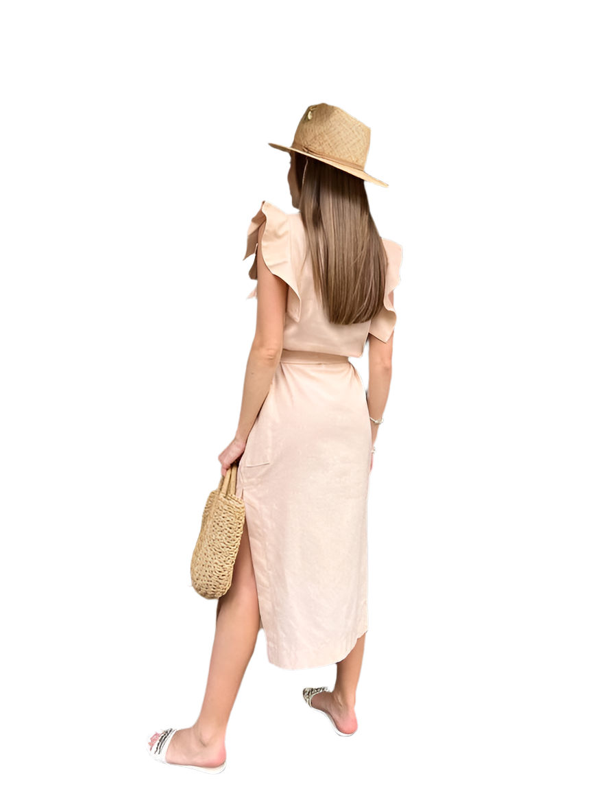 Woman wearing a beige dress and hat, holding a straw bag on a white background