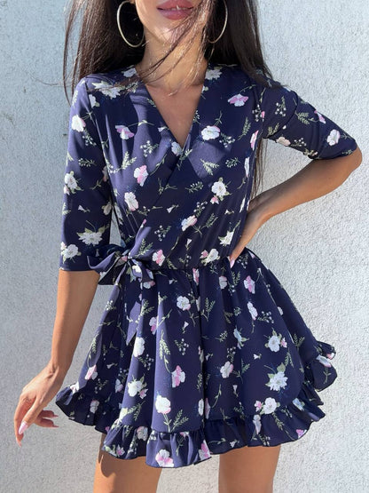 Woman wearing a navy floral dress against a light gray background