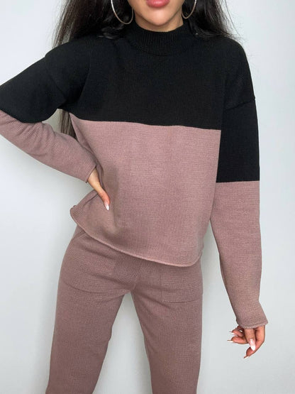 Two-tone black and pink sweater set on a plain background