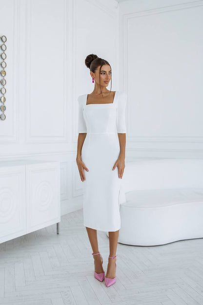 Woman wearing a white dress with a plain background