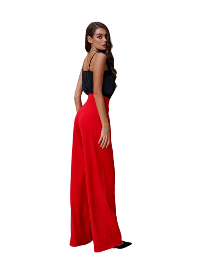 Woman wearing a black top and red wide-leg pants on a white background