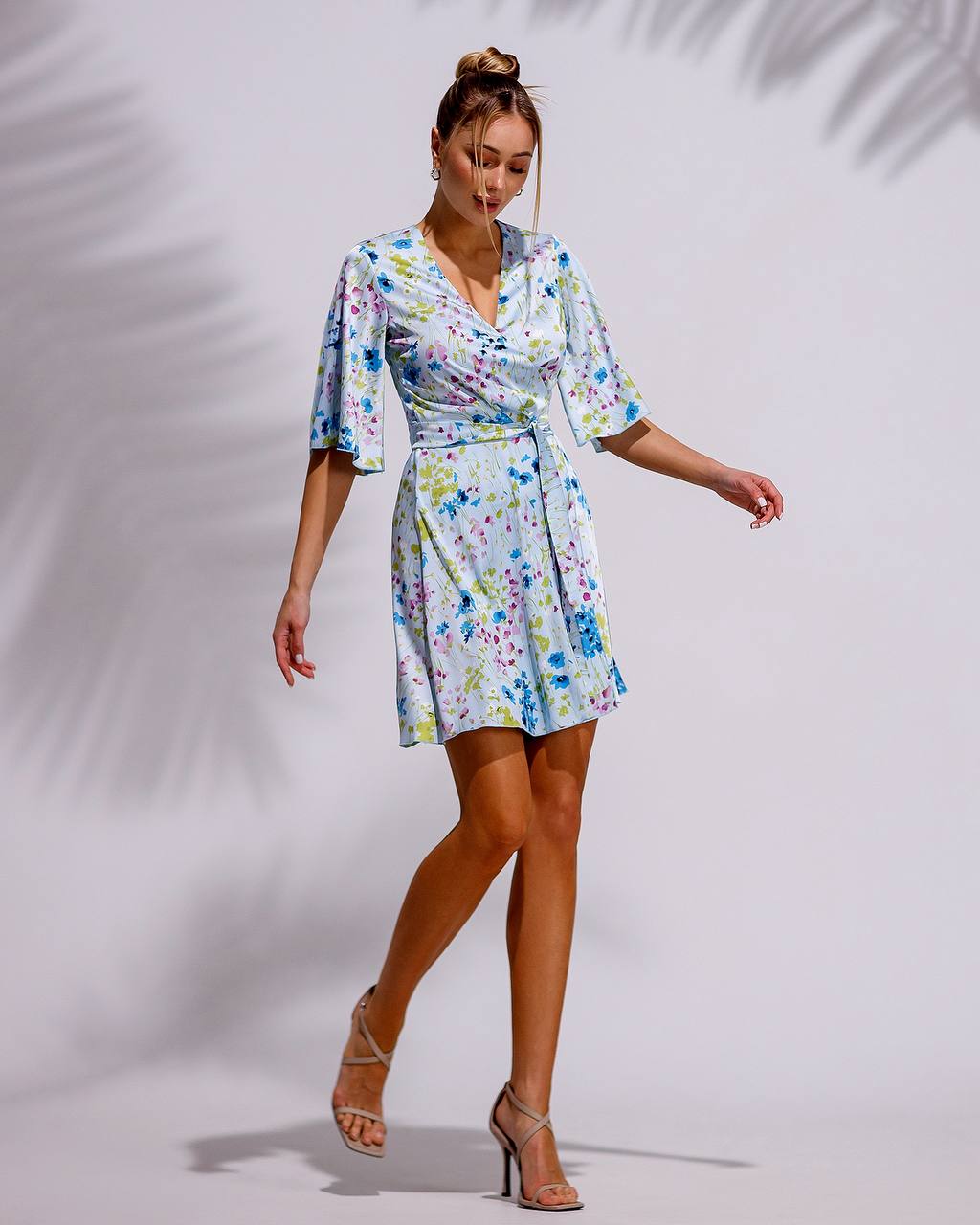 Woman wearing a floral dress against a plain background