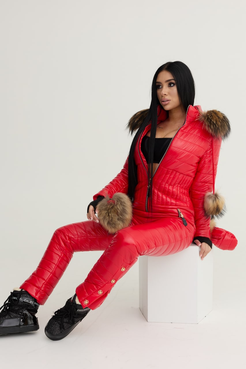 Person wearing a red puffer suit with fur trim on a white background