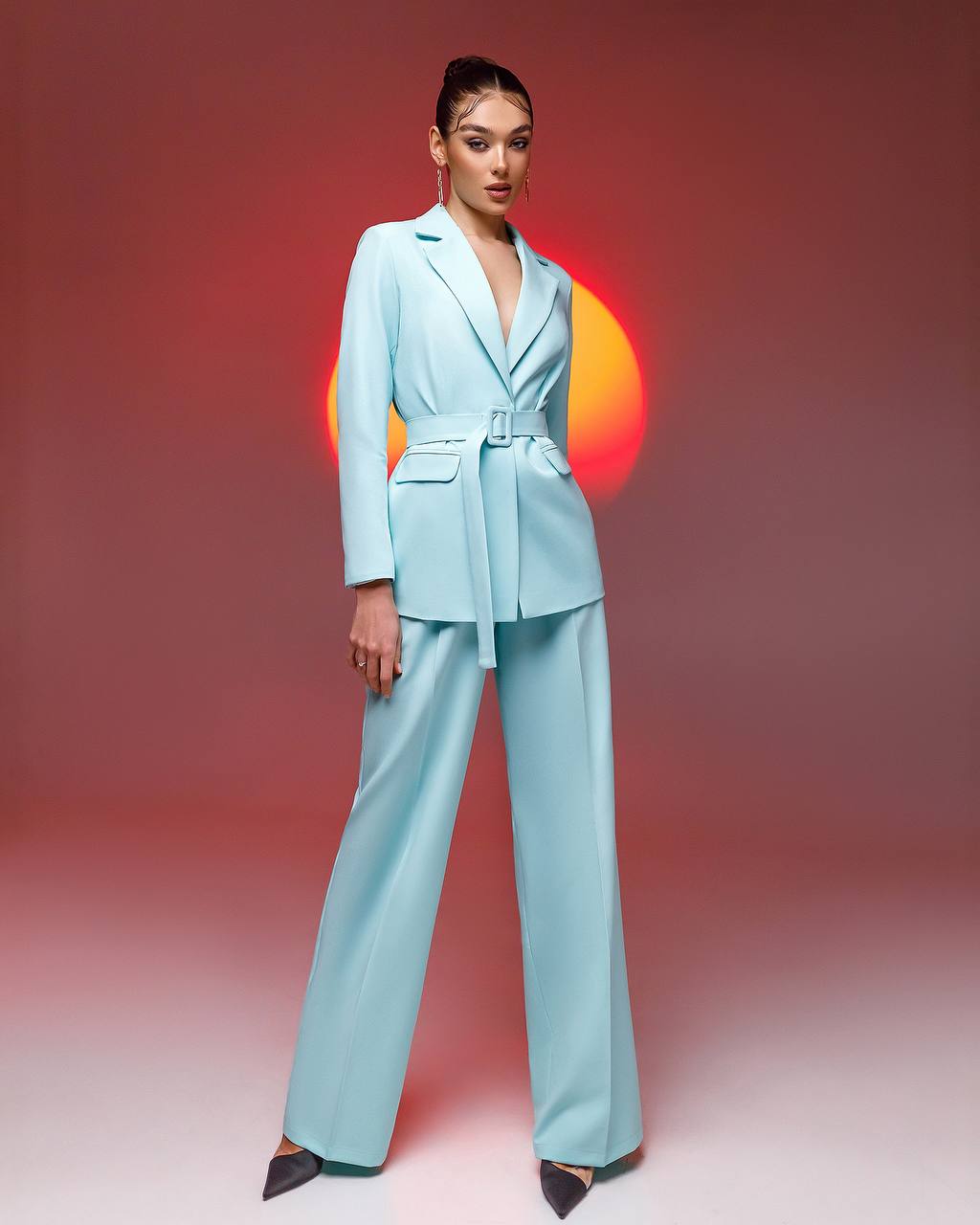 Woman wearing a light blue suit against a gradient background