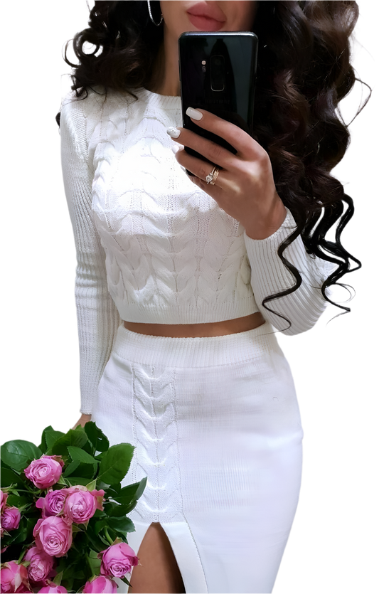 Person wearing a white cable knit top and white skirt holding pink roses.