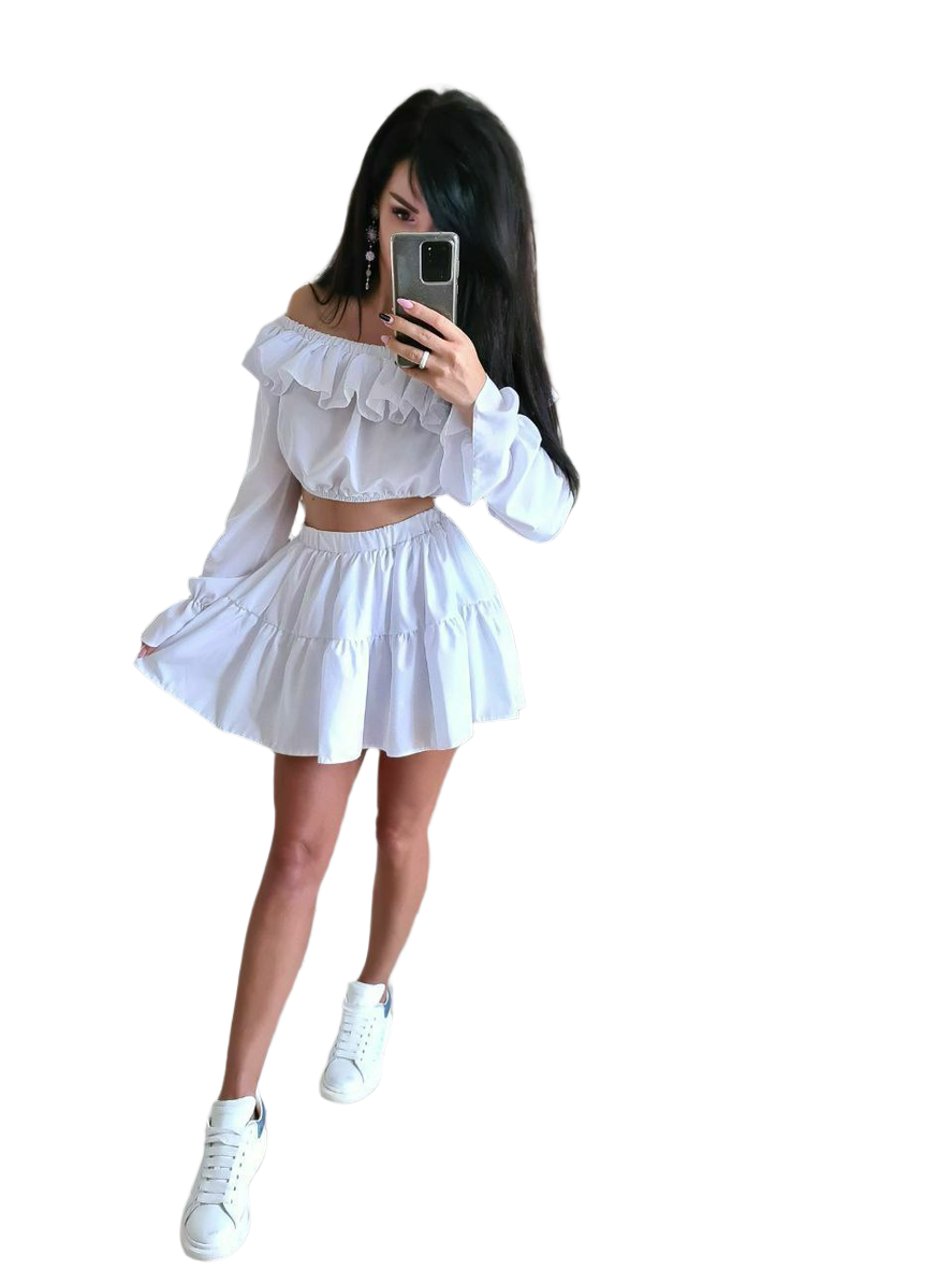 Woman taking a mirror selfie wearing a white outfit with ruffled details on a white background