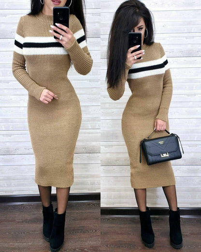 Woman wearing a beige ribbed dress with black and white stripes, holding a black handbag.