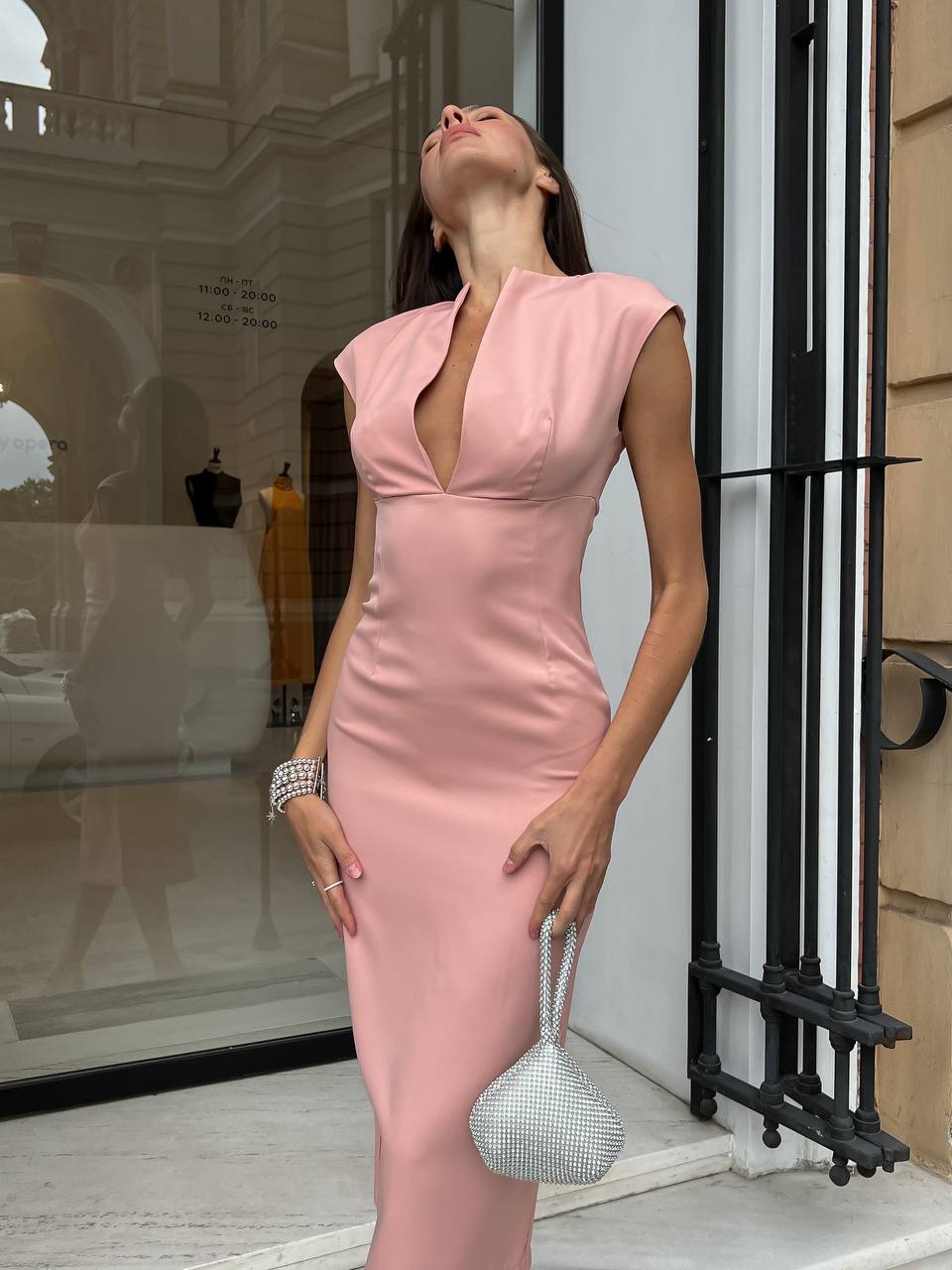 Woman in a pink dress standing outside a building