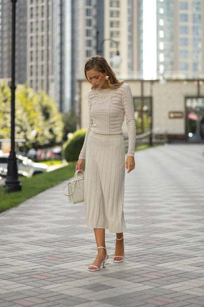 Woman in a beige outfit walking on a city street