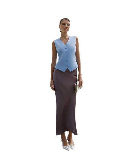 Woman wearing a light blue vest over a brown dress on a white background
