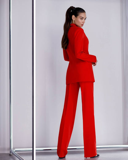 Woman wearing a red suit standing against a white background