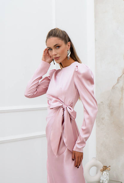 Woman wearing a pink satin dress with a white background