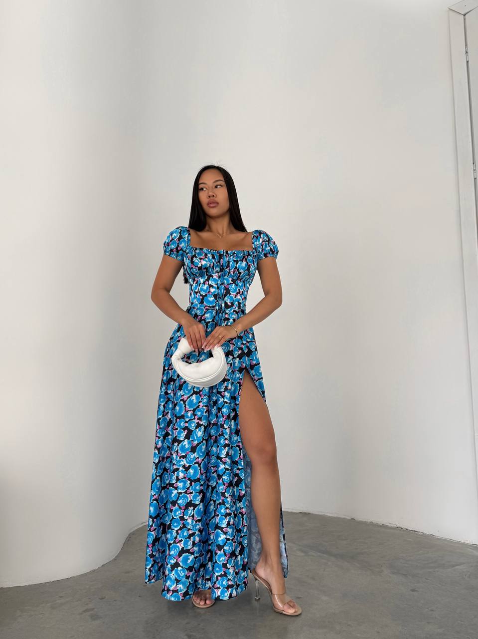 Woman wearing a blue floral dress with a white background