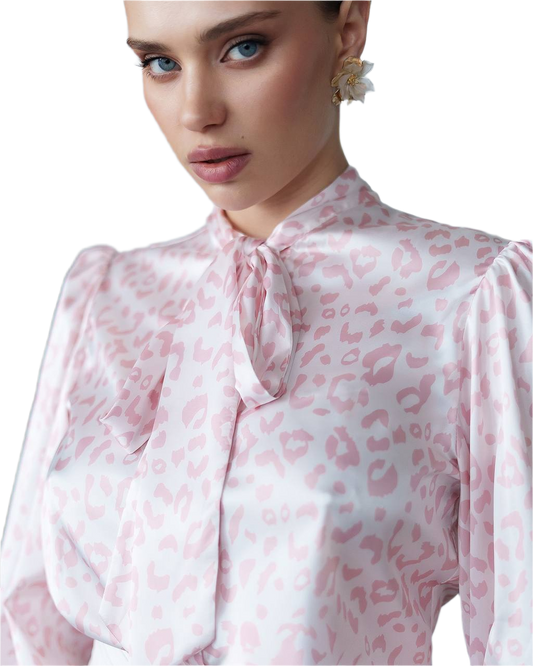 Woman wearing a pink leopard print blouse with a white background