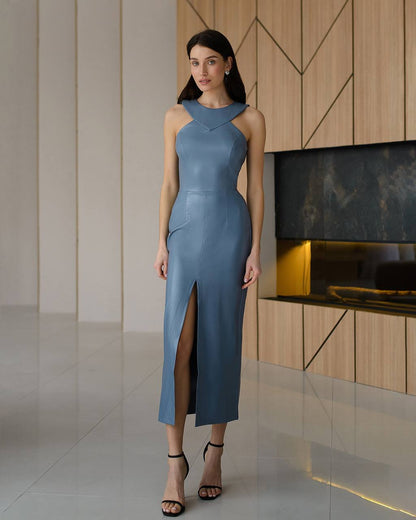 Woman wearing a blue dress in an indoor setting with wooden panels and a fireplace.