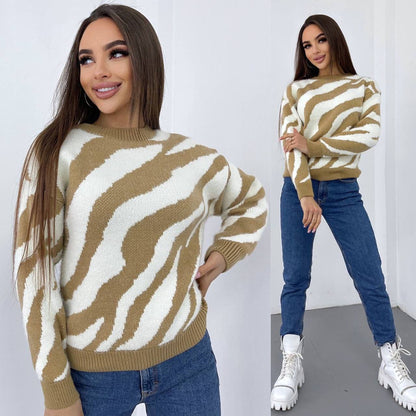 Woman wearing a zebra pattern sweater and blue jeans against a white background