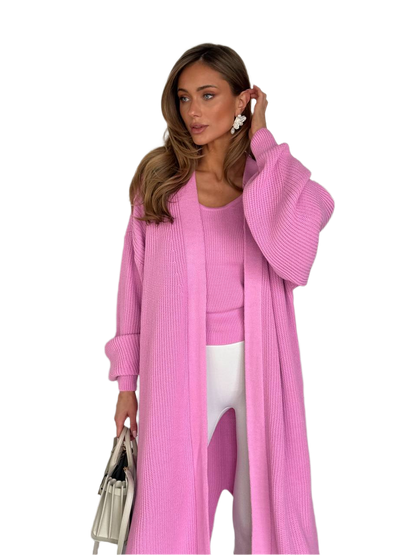 Woman wearing a pink cardigan and white pants on a white background