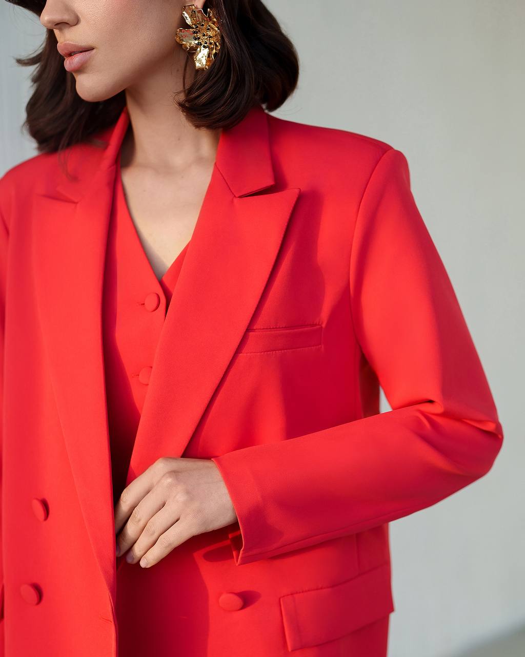 Person wearing a bright red suit with a neutral background