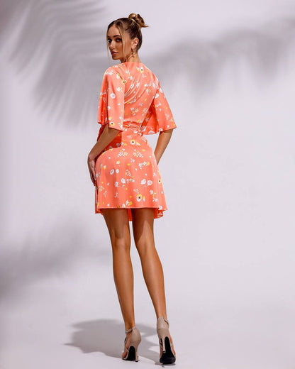 Woman wearing a coral floral dress on a white background