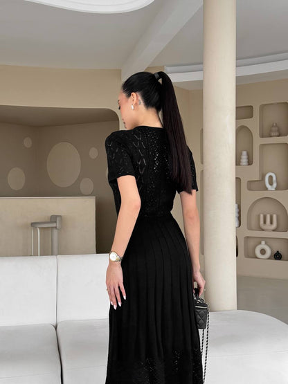 Woman in a black dress standing in a modern interior setting