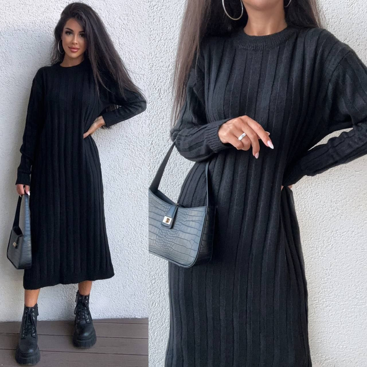 Woman wearing a black ribbed dress with long sleeves, holding a gray handbag against a white wall.