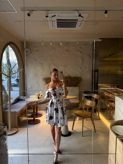 Person taking a mirror selfie in a modern cafe.