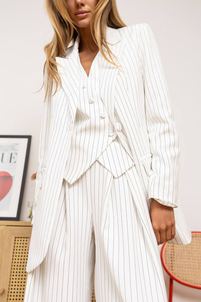 Woman wearing a white pinstripe suit in an indoor setting.