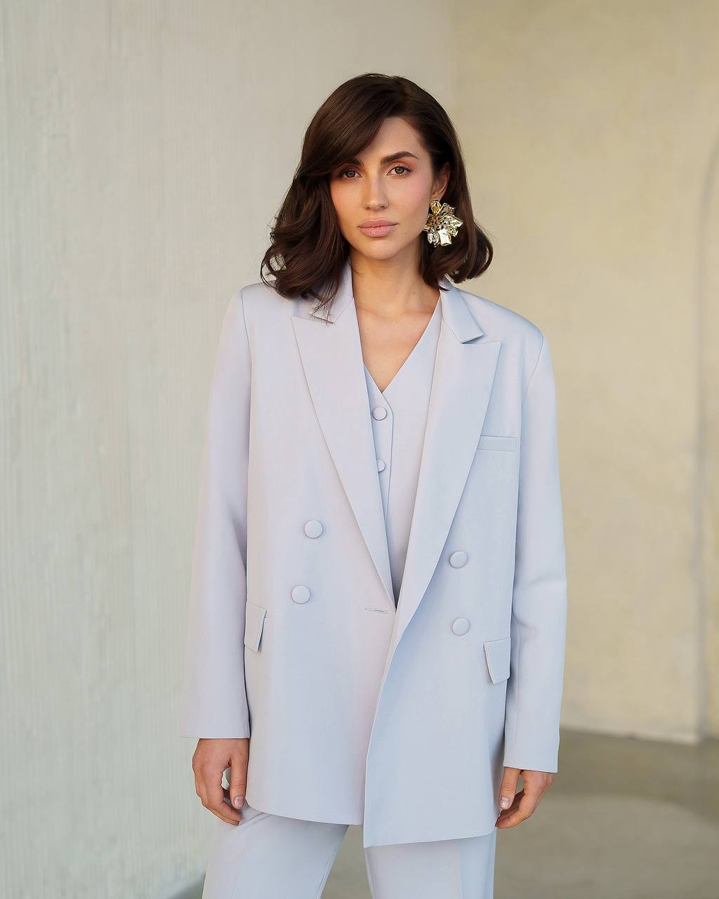 Woman wearing a light blue suit with a neutral background