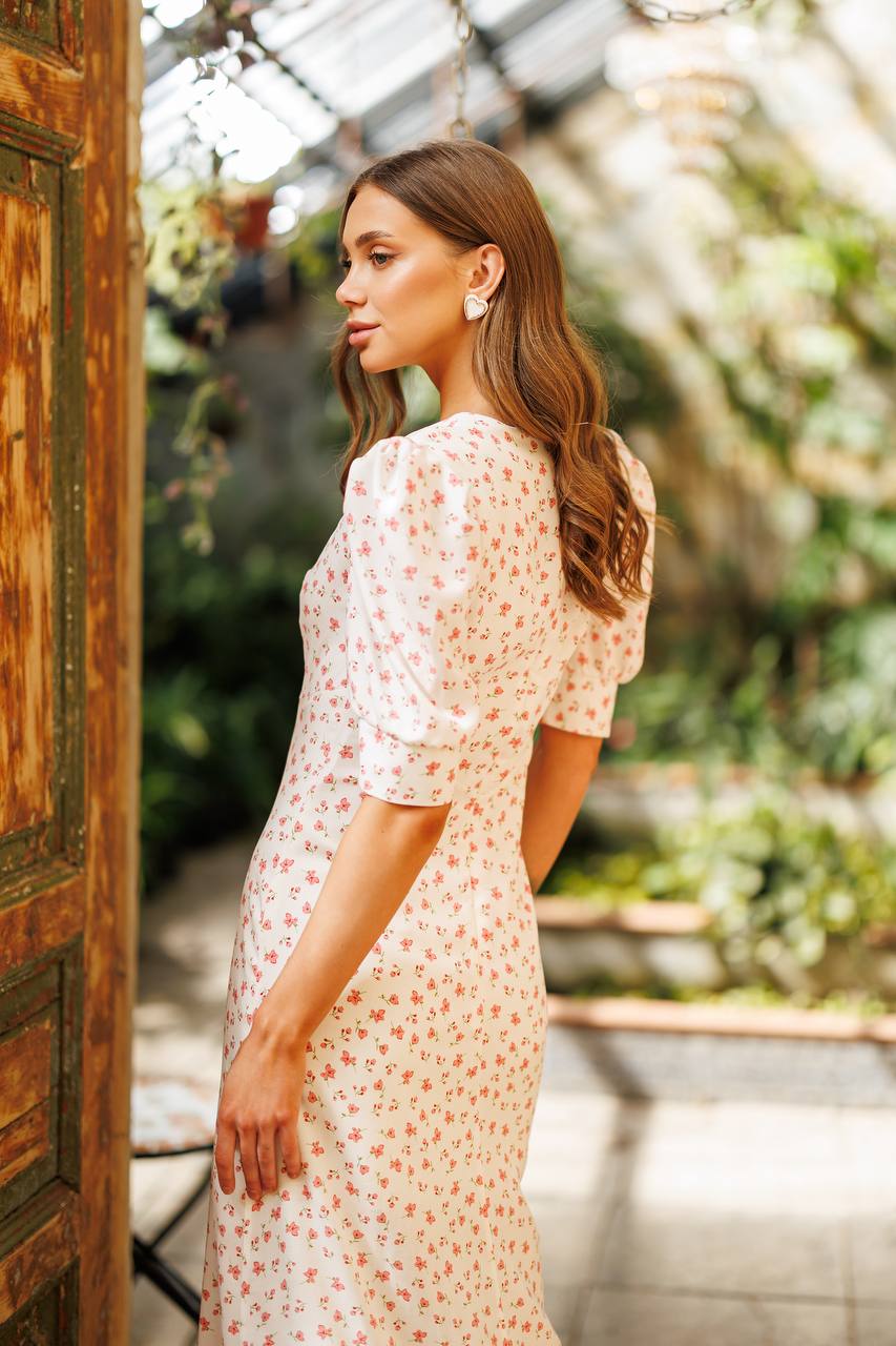 Woman in a floral dress standing in a greenhouse
