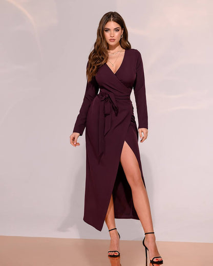 Woman wearing a burgundy wrap dress with a slit on a plain background