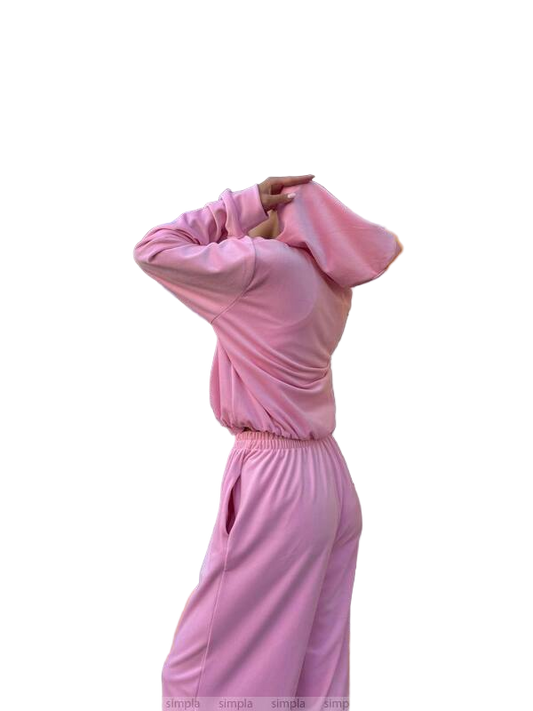 Person wearing a pink tracksuit on a white background