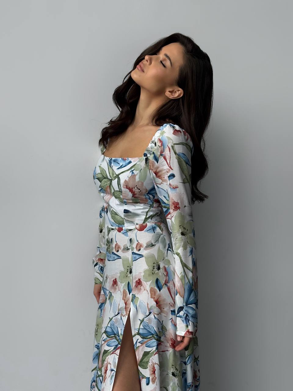 Woman wearing a floral dress against a gray background