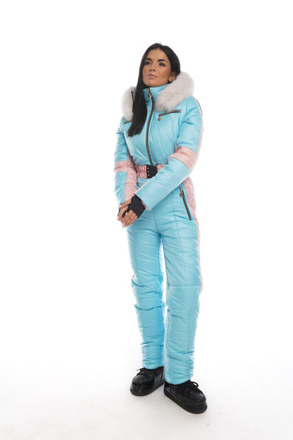 Person wearing a light blue snowsuit with pink accents on a white background