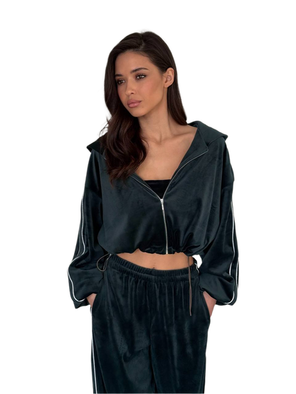 Woman wearing a dark green tracksuit with a hood on a white background