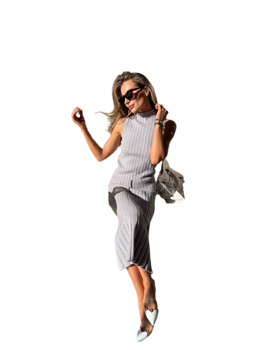Woman in a gray dress with sunglasses and a handbag on a white background
