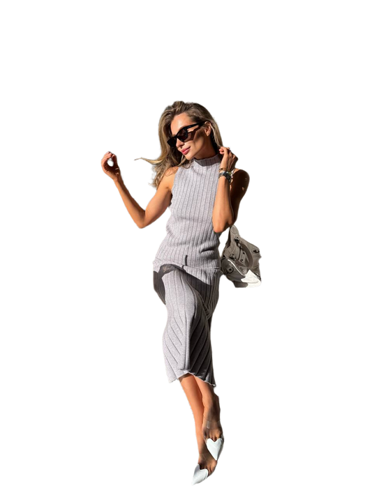 Woman in a gray dress with sunglasses and a handbag on a white background