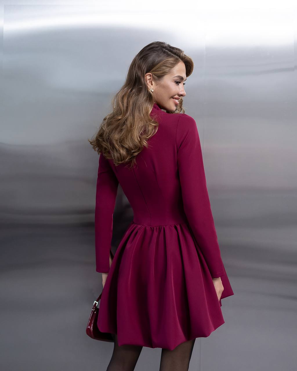 Woman wearing a burgundy dress against a neutral background