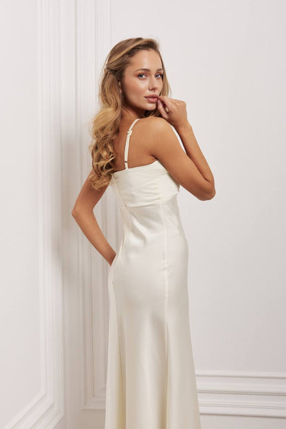 Woman wearing a white dress against a white wall