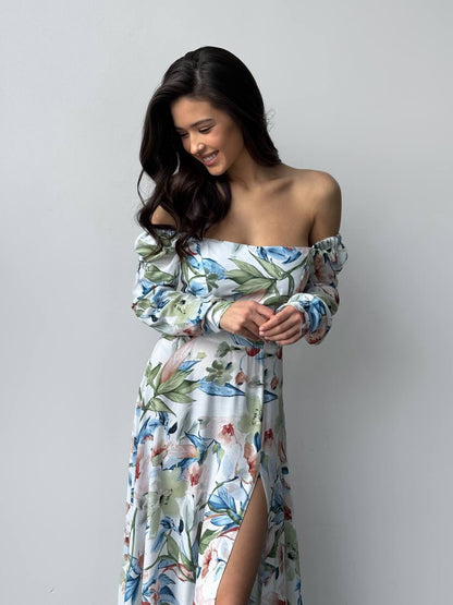 Woman wearing a floral off-shoulder dress against a plain background