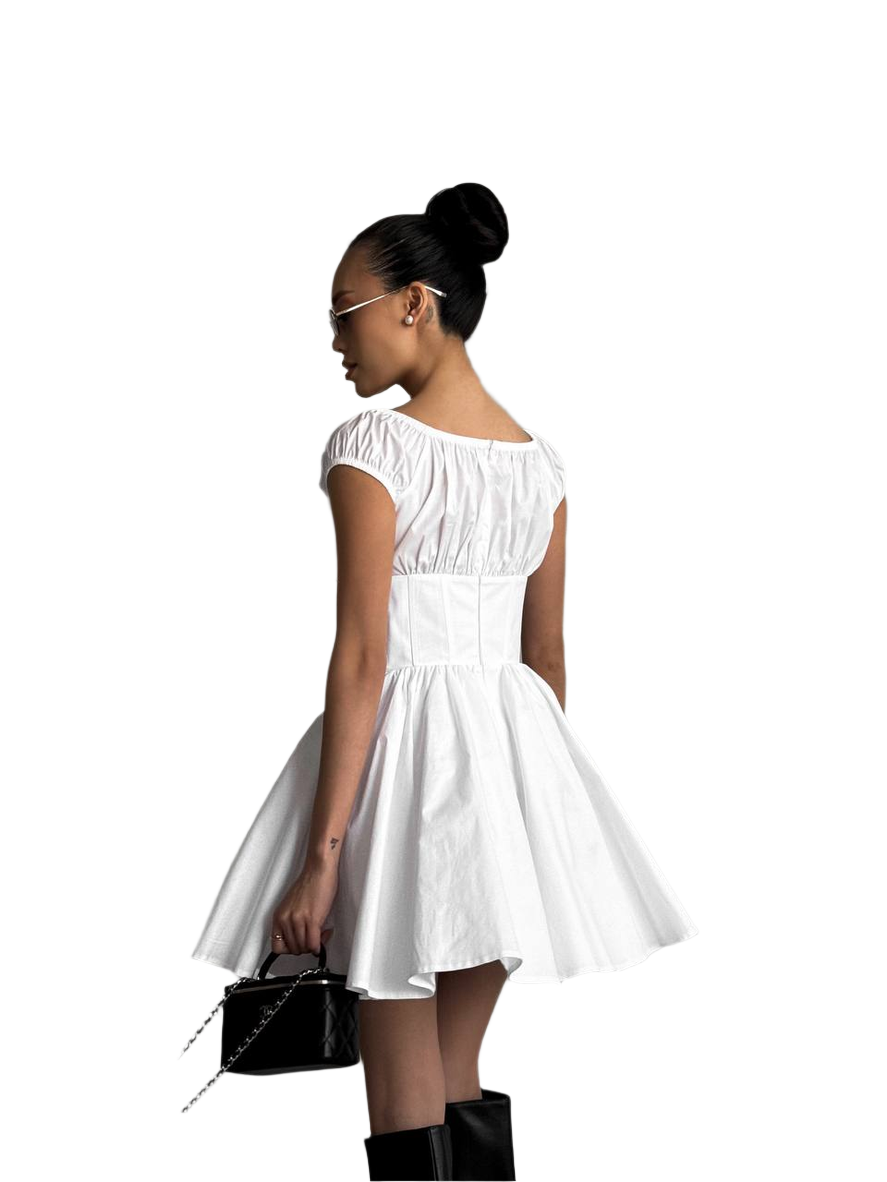 Woman wearing a white dress with a black handbag on a white background