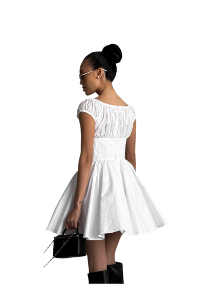 Woman wearing a white dress with a black handbag on a white background