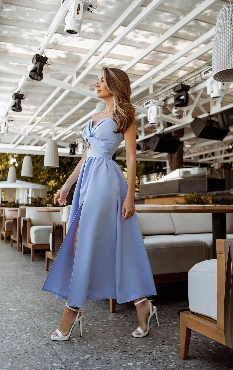 Woman in a light blue dress standing in a modern restaurant.